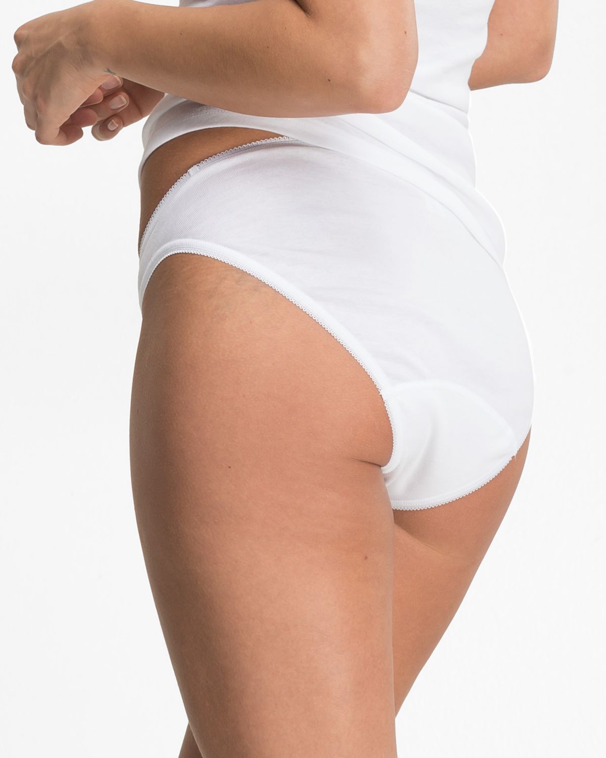 Model trägt Bikinislip in weiß aus der Serie Noelle, Ansicht von hinten.