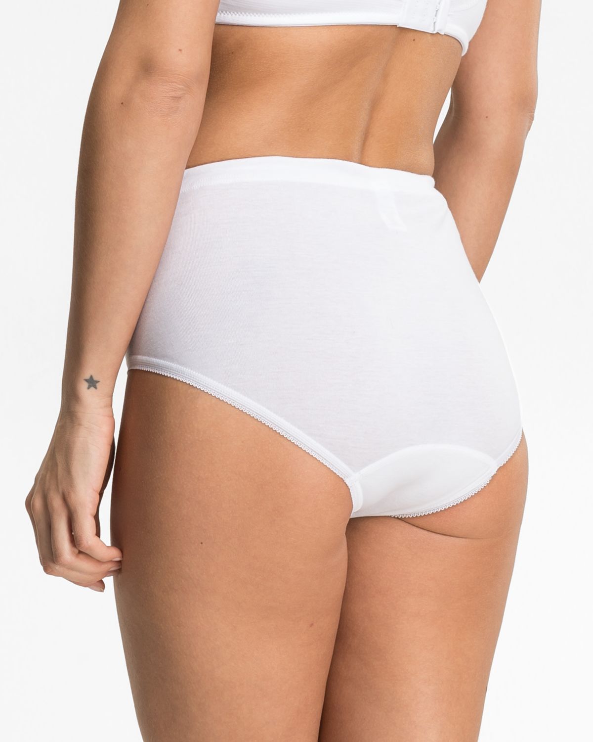 Model trägt Taillenslip in weiß aus der Serie Noelle, Ansicht von hinten.