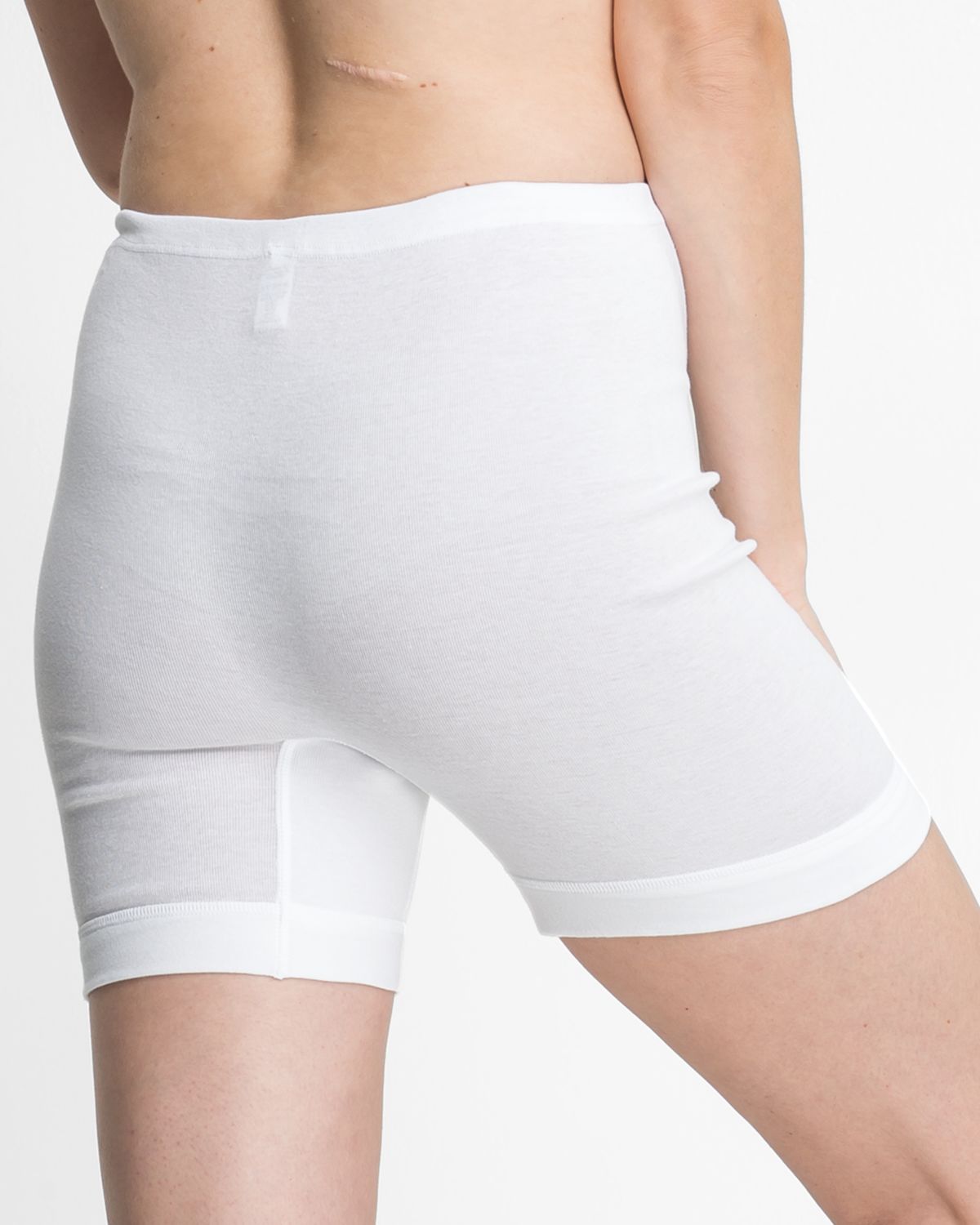 Model trägt Langbeinschlüpfer in weiß aus der Serie Nelly, Ansicht von hinten.