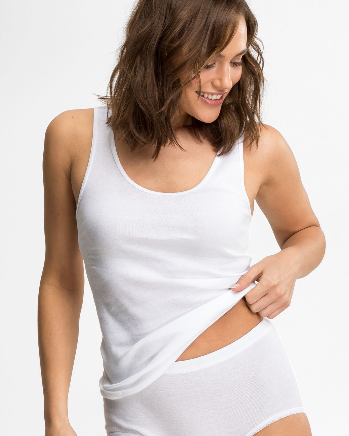 Model trägt Achselhemd in weiß aus der Serie Nelly, Ansicht von vorne.