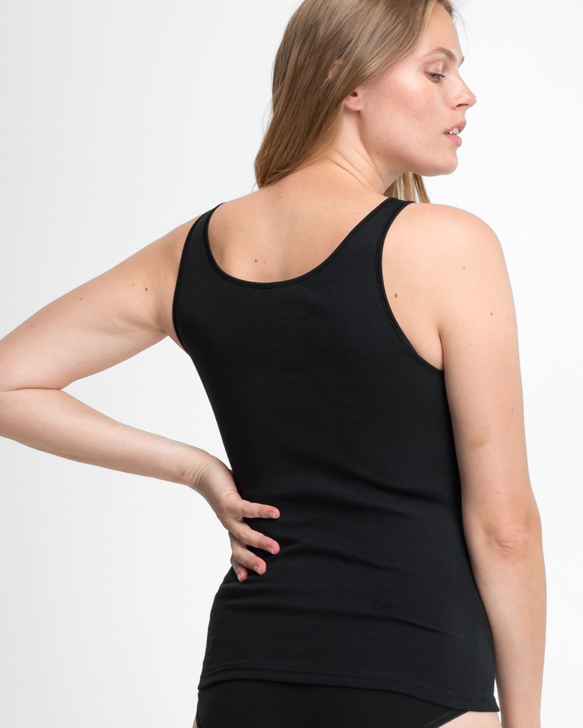 Model trägt Achselhemd in schwarz aus der Serie Natalie, Ansicht von hinten.