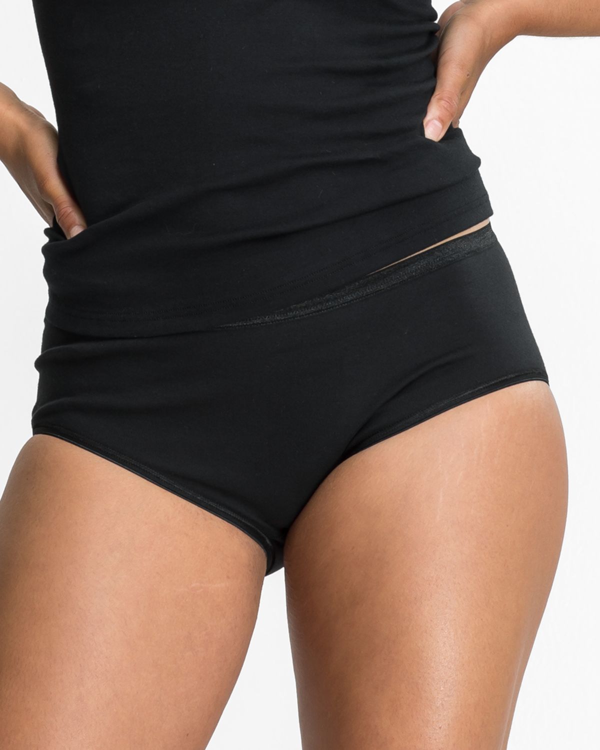 Model trägt Midislip in schwarz aus der Serie Natascha, Ansicht von vorne.