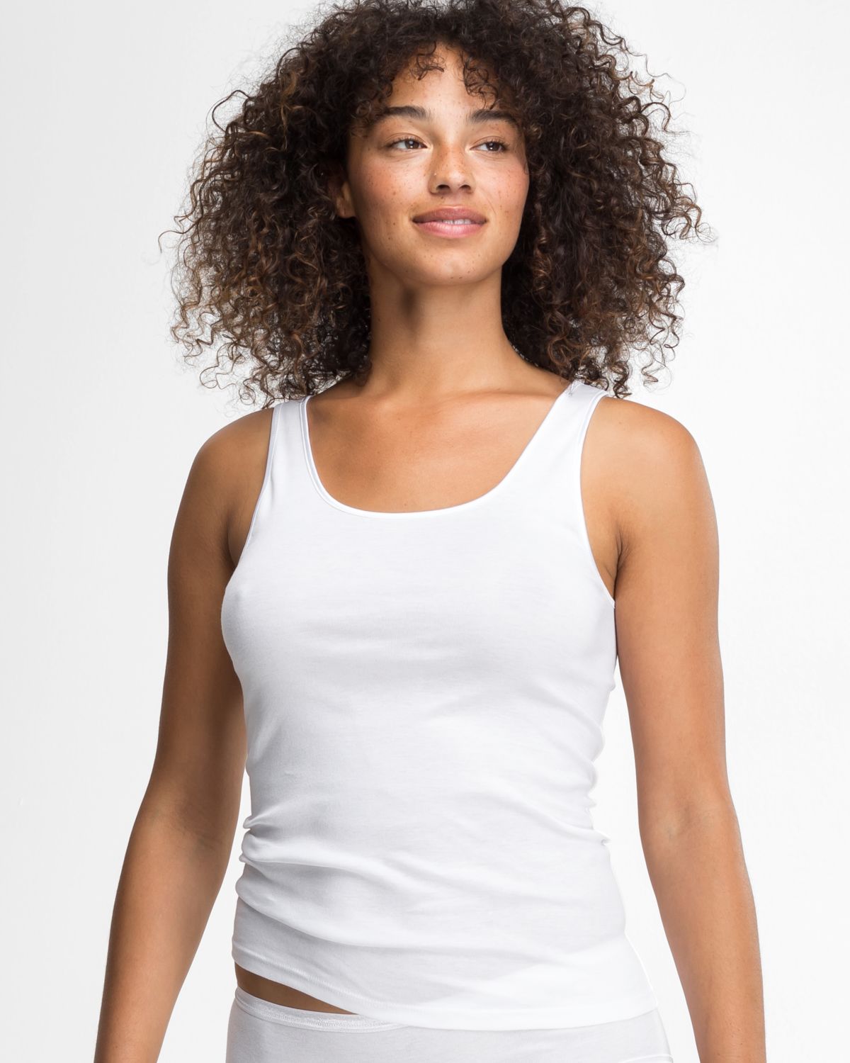 Model trägt Achselhemd in weiß aus der Serie Natascha, Ansicht von vorne.