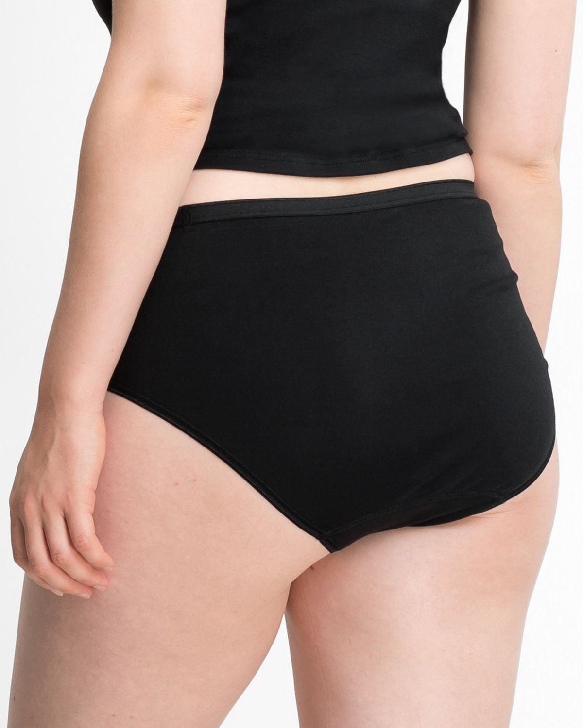 Model trägt Maxislip in schwarz aus der Serie Lingerie Plus, Ansicht von hinten.