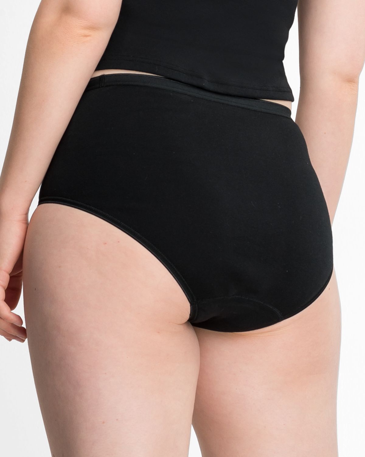 Model trägt Maxislip in schwarz aus der Serie Lingerie Plus, Ansicht von hinten.