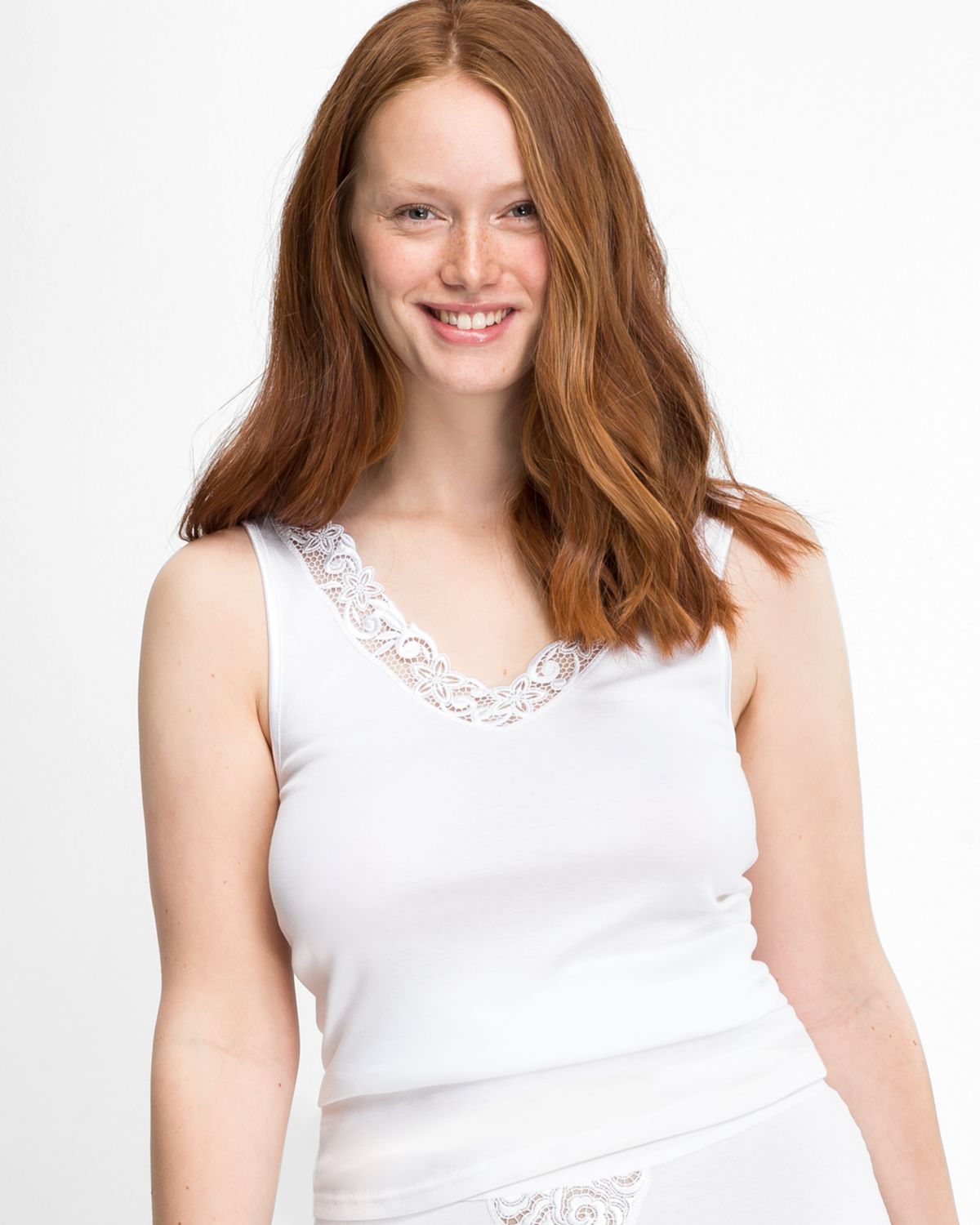 Model trägt Achselhemd in weiß aus der Serie Lingerie Plus, Ansicht von vorne.