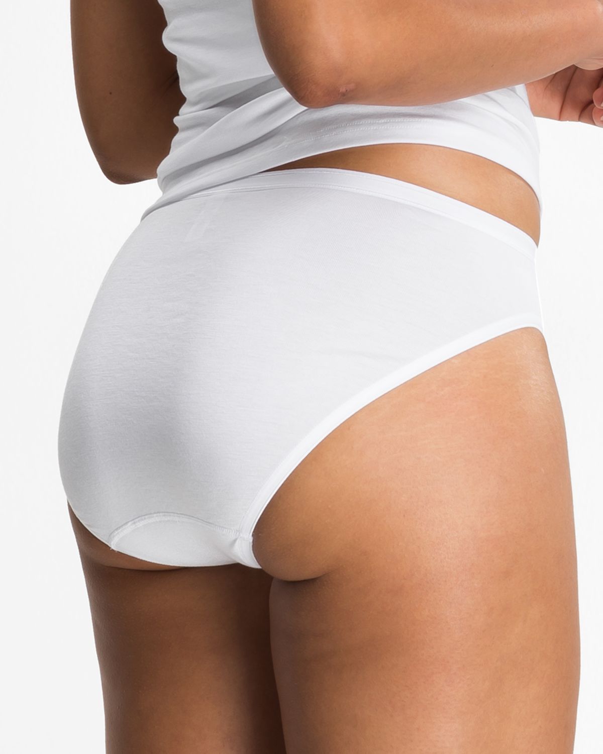 Model trägt Jazzpant in weiß aus der Serie Nadine, Ansicht von hinten.