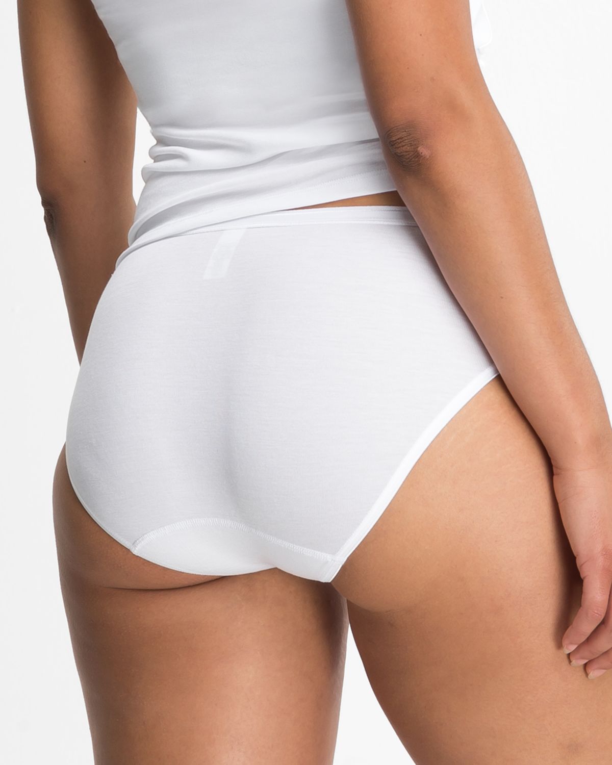 Model trägt Hüftslip in weiß aus der Serie Nadine, Ansicht von hinten.