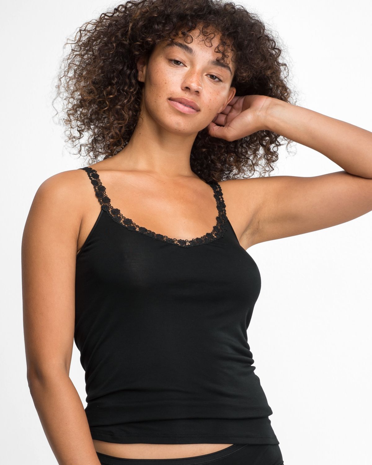 Model trägt Trägerhemd in schwarz aus der Serie Nadine, Ansicht von vorne.