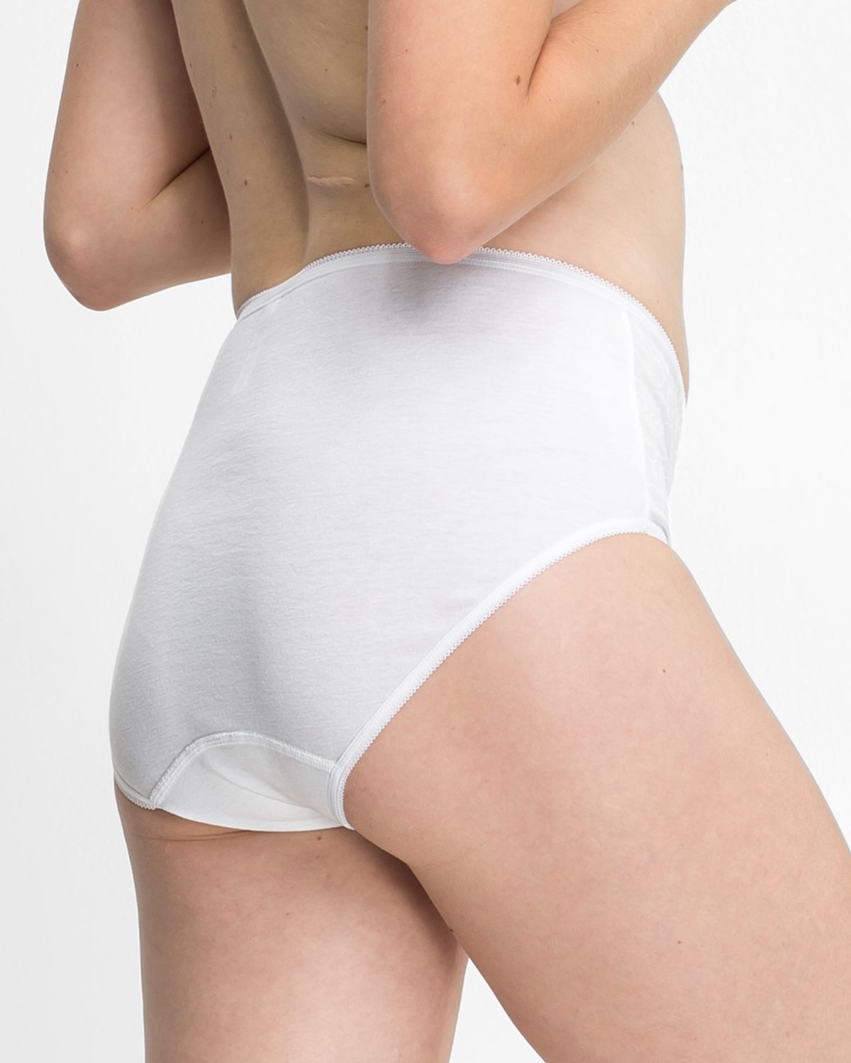 Model trägt Taillenslip in weiß aus der Serie Britta, Ansicht von hinten.