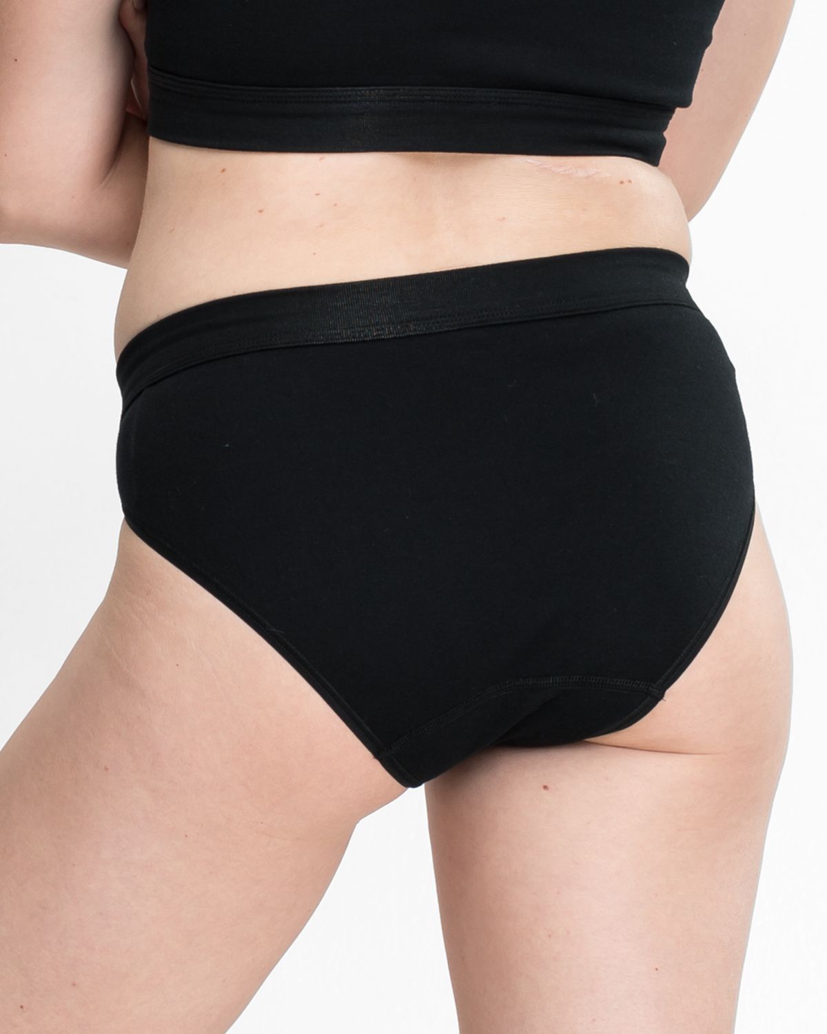 Model trägt Jazzpant in schwarz aus der Serie Bio Cotton, Ansicht von hinten.