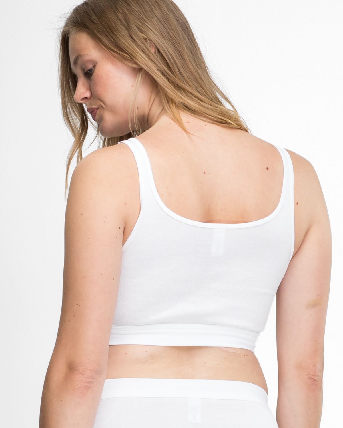 Model trägt Trägerbustier in weiß aus der Serie Bio Cotton, Ansicht von hinten.