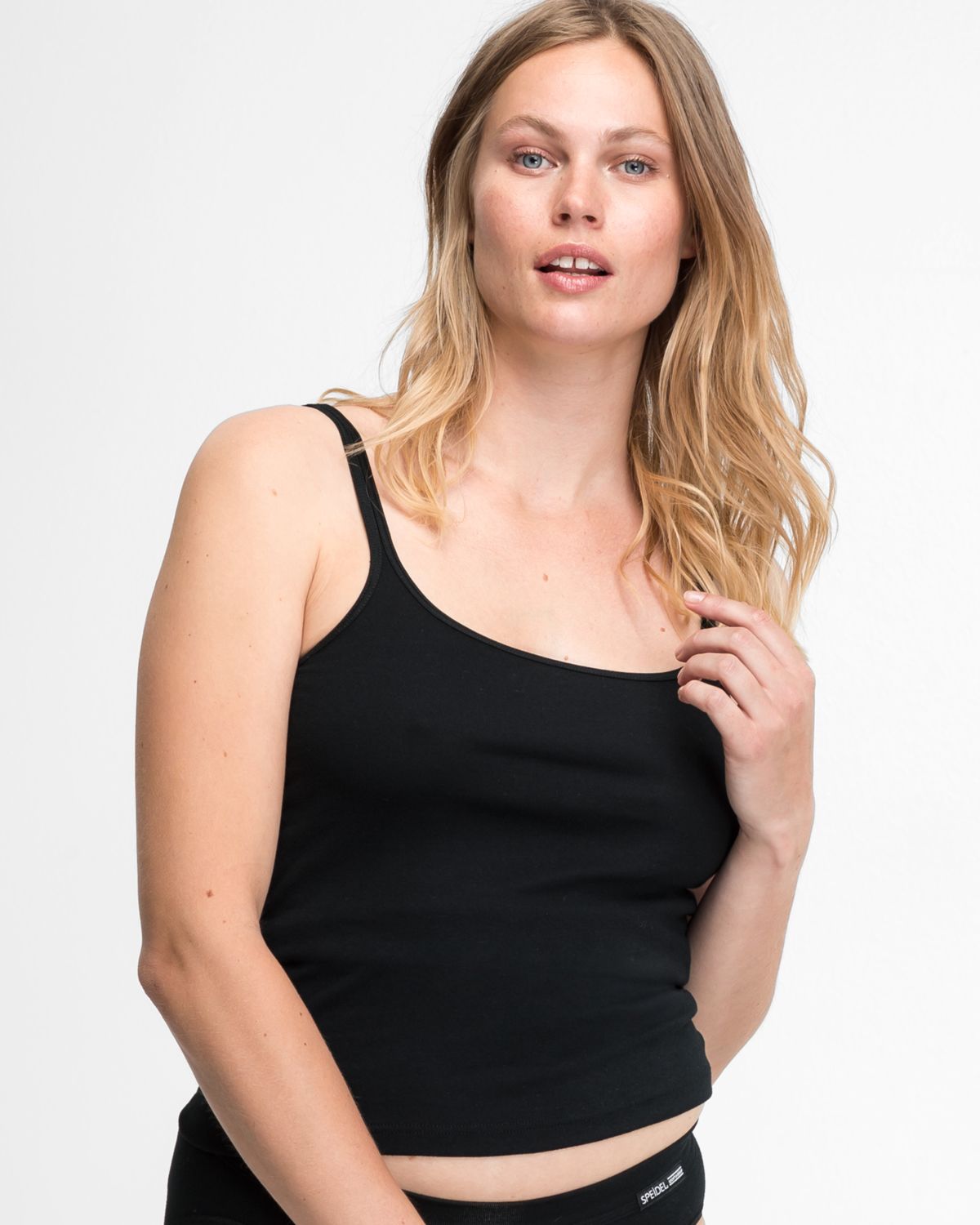 Model trägt Trägerhemd in schwarz aus der Serie Bio Cotton, Ansicht von vorne.