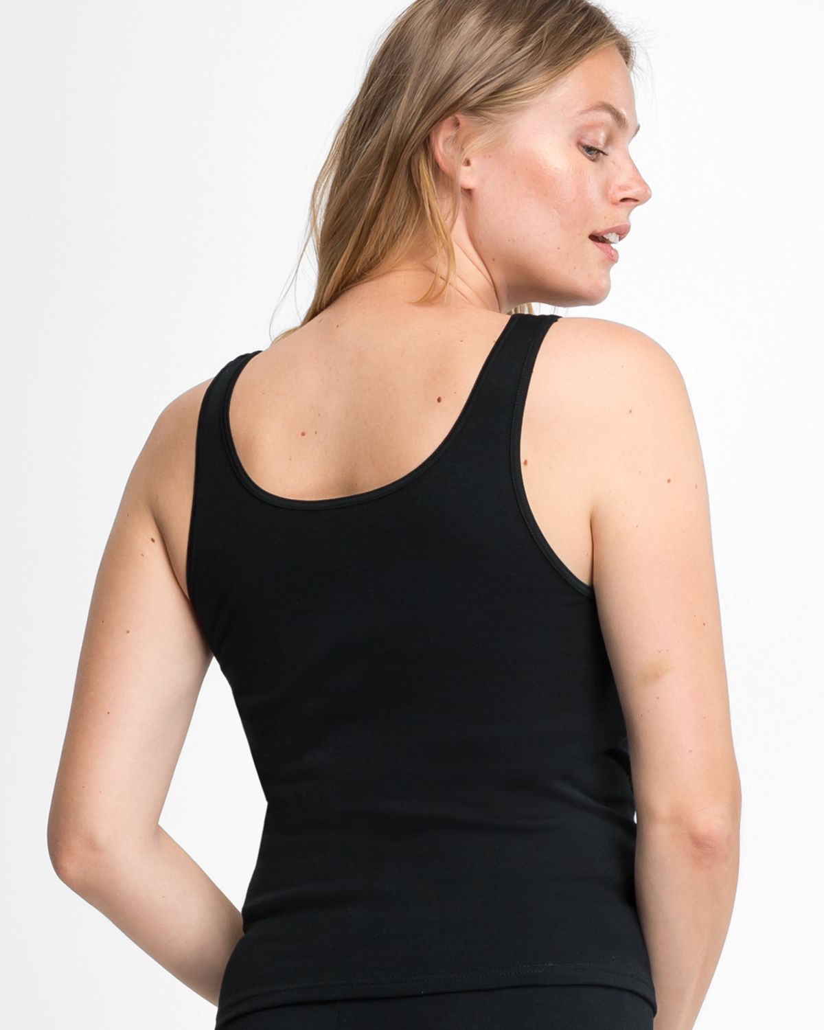 Model trägt Achselhemd in schwarz aus der Serie Bio Cotton, Ansicht von hinten.