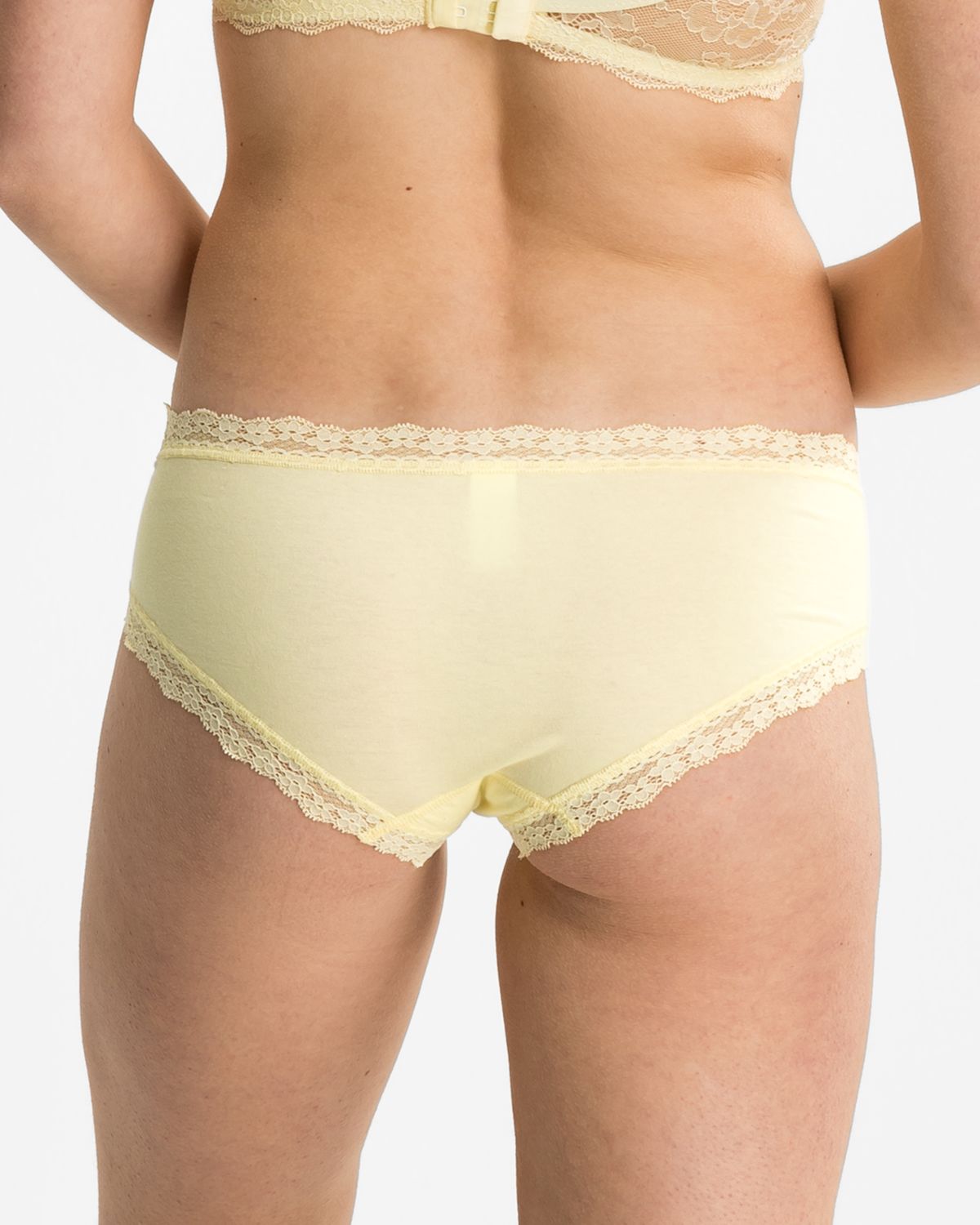Model trägt Low Hip in zitrone aus der Serie Lacy, Ansicht von hinten.