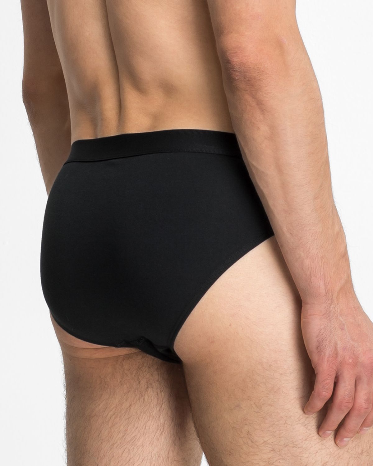 Model trägt Herren Slip in schwarz aus der Serie Classic, Ansicht von hinten.