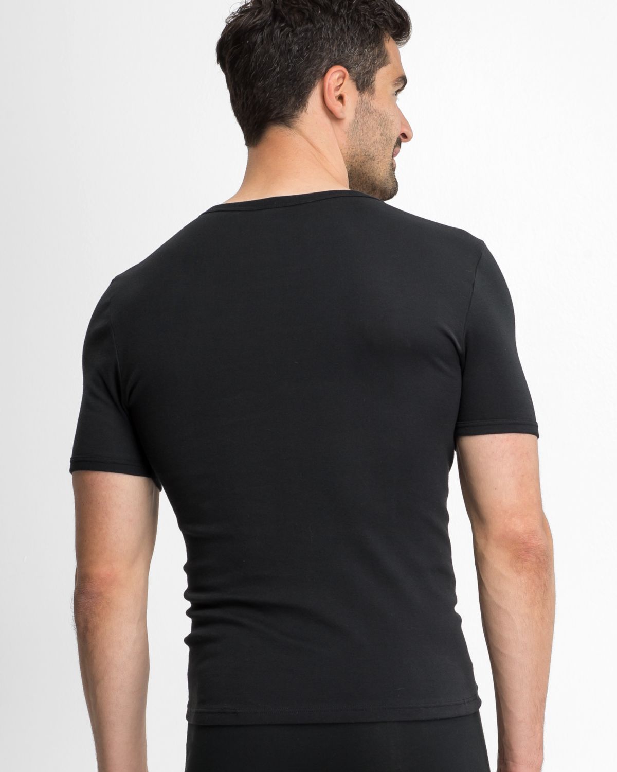 Model trägt Herrenhemd 1/2 Arm in schwarz aus der Serie Classic, Ansicht von hinten.