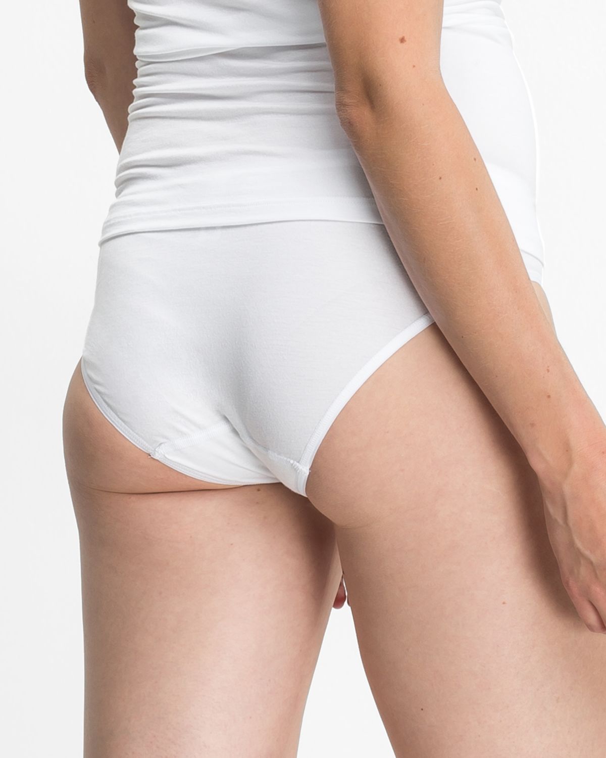 Model trägt Minislip in weiß aus der Serie Sensuelle, Ansicht von hinten.