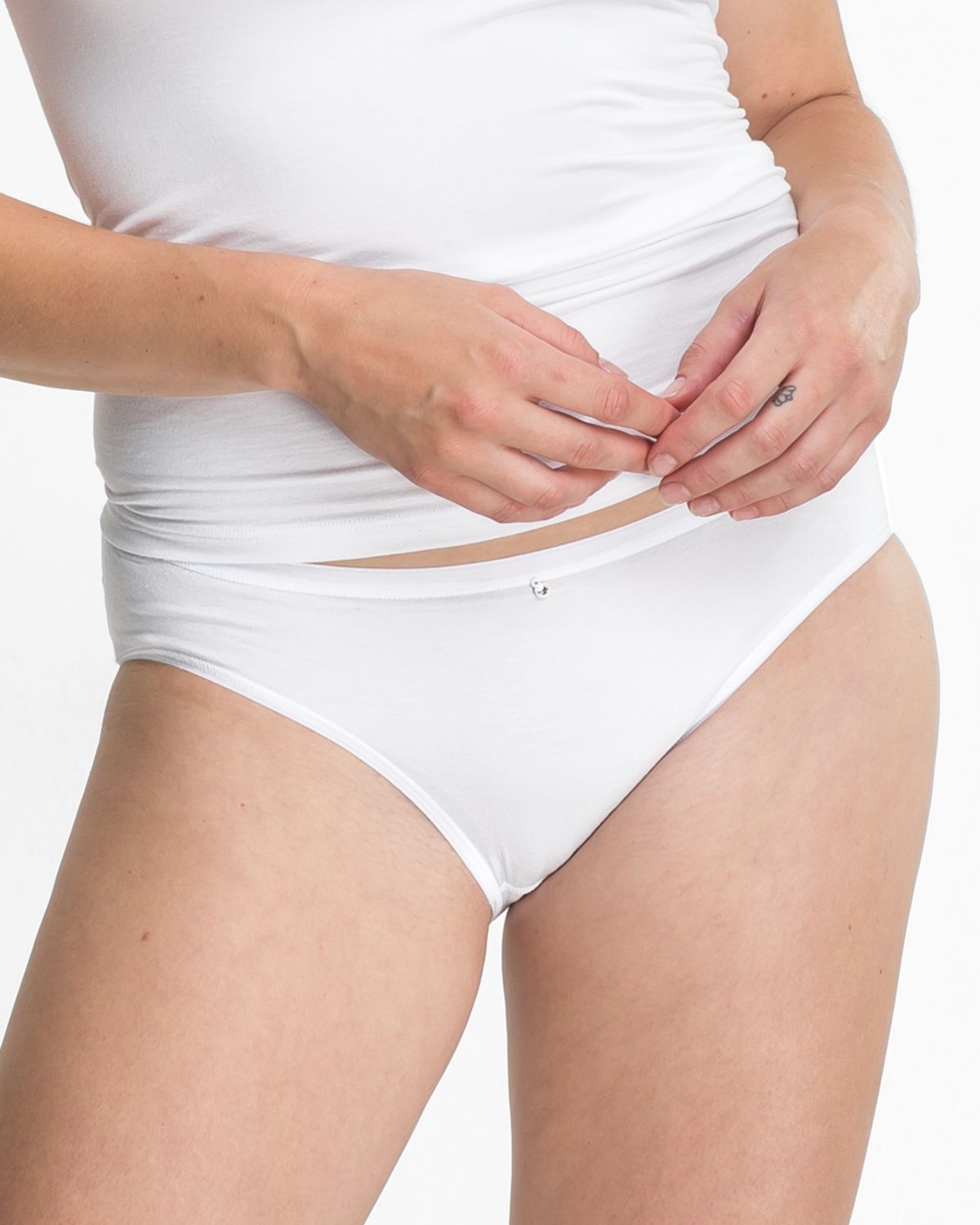 Model trägt Minislip in weiß aus der Serie Sensuelle, Ansicht von vorne.
