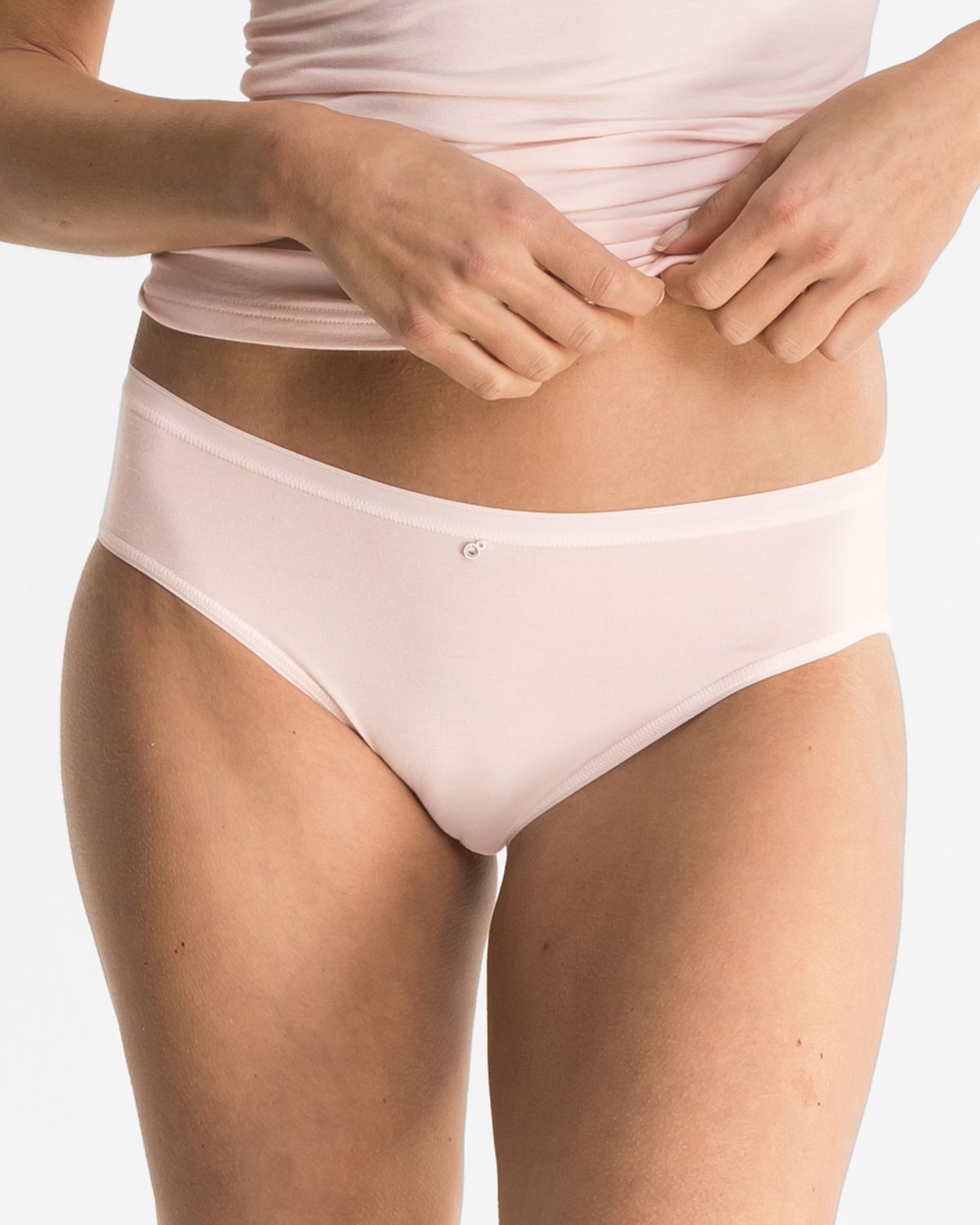 Model trägt Minislip in lychee aus der Serie Sensuelle, Ansicht von vorne.