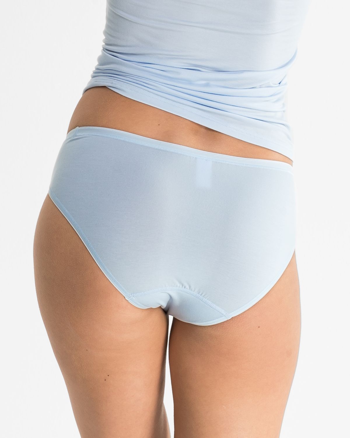 Model trägt Minislip in aquamarin aus der Serie Sensuelle, Ansicht von hinten.