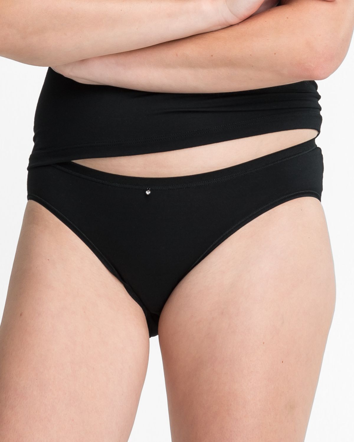 Model trägt Minislip in schwarz aus der Serie Sensuelle, Ansicht von vorne.