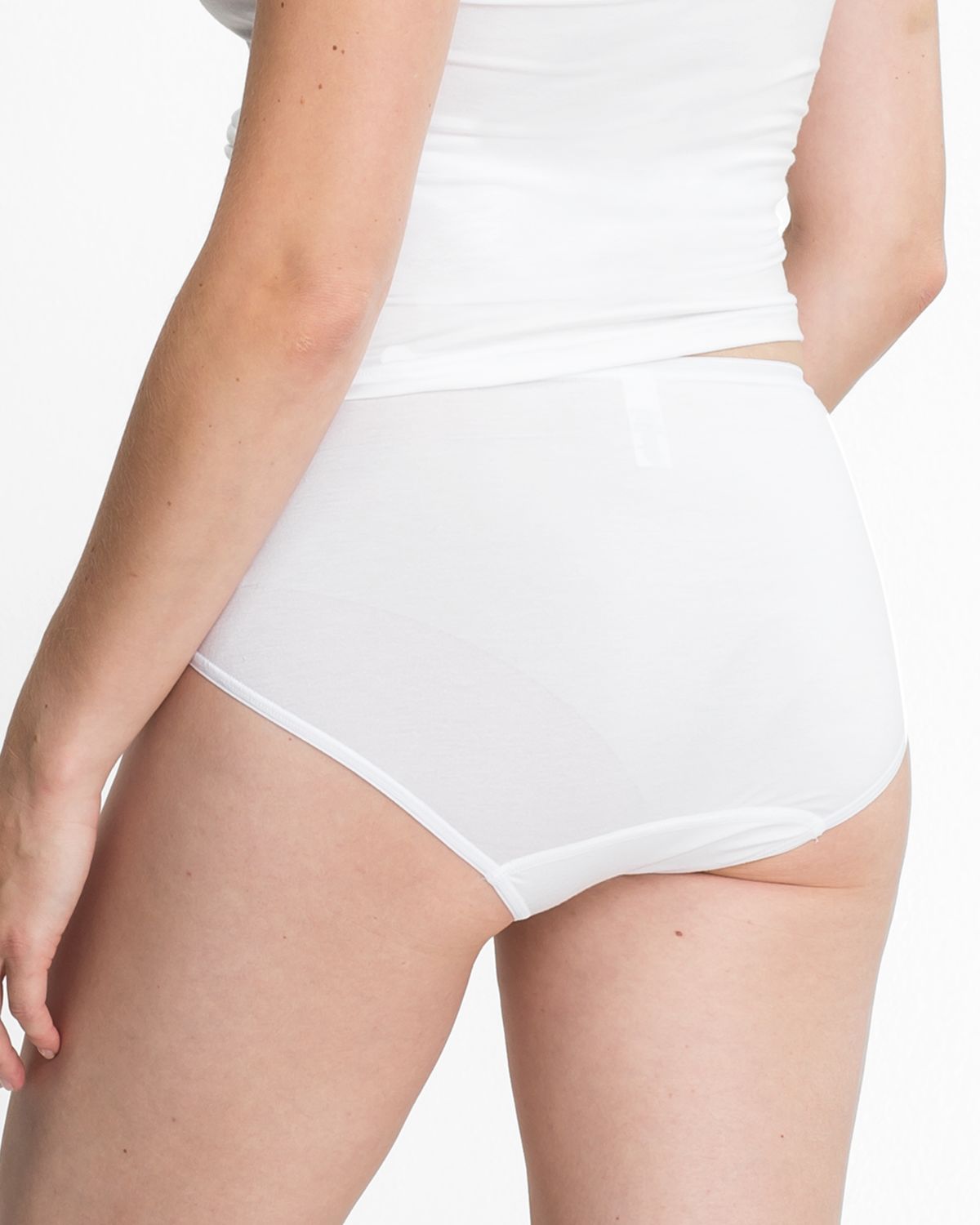 Model trägt Midislip in weiß aus der Serie Sensuelle, Ansicht von hinten.