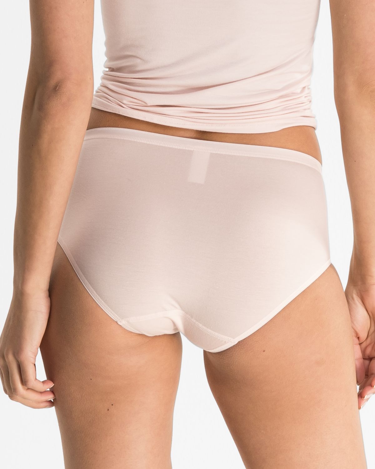 Model trägt Midislip in lychee aus der Serie Sensuelle, Ansicht von hinten.