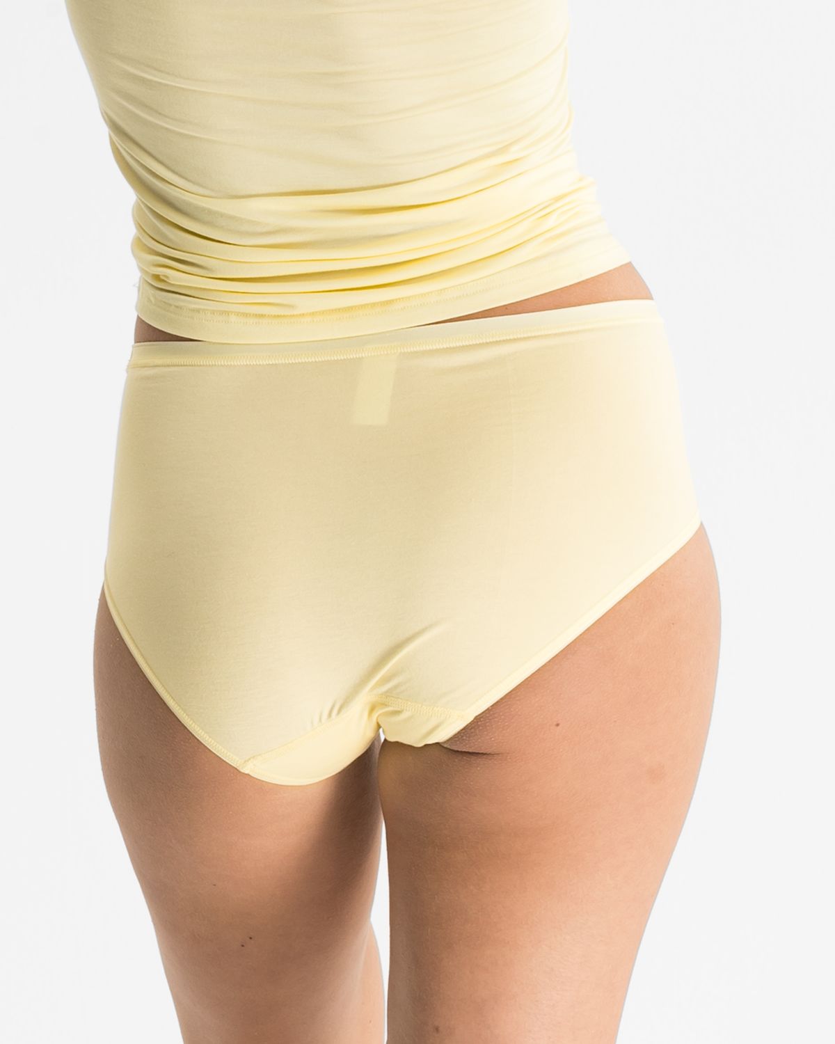 Model trägt Midislip in zitrone aus der Serie Sensuelle, Ansicht von hinten.