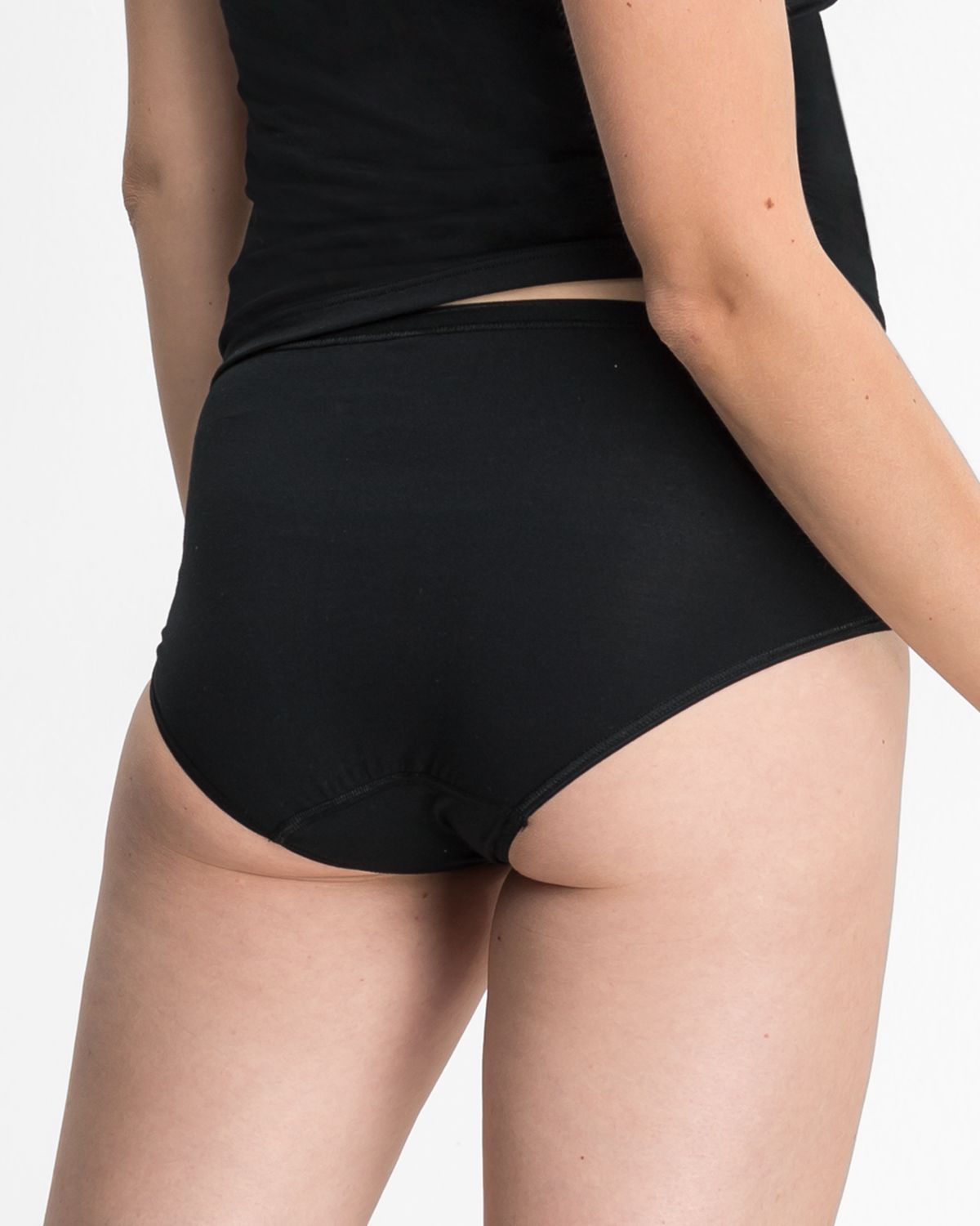 Model trägt Midislip in schwarz aus der Serie Sensuelle, Ansicht von hinten.