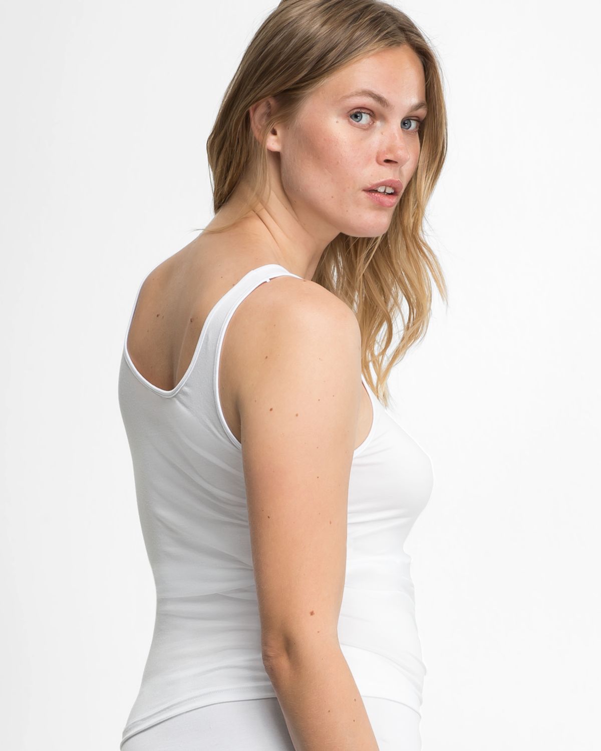 Model trägt Achselhemd in weiß aus der Serie Sensuelle, Ansicht von hinten.