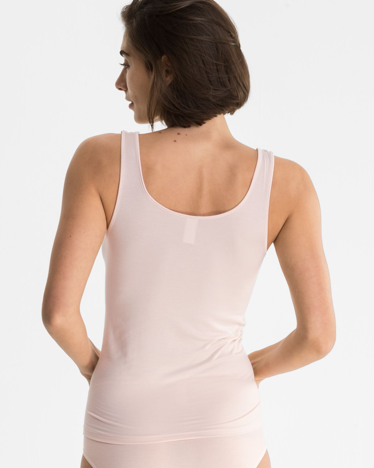 Model trägt Achselhemd in lychee aus der Serie Sensuelle, Ansicht von hinten.