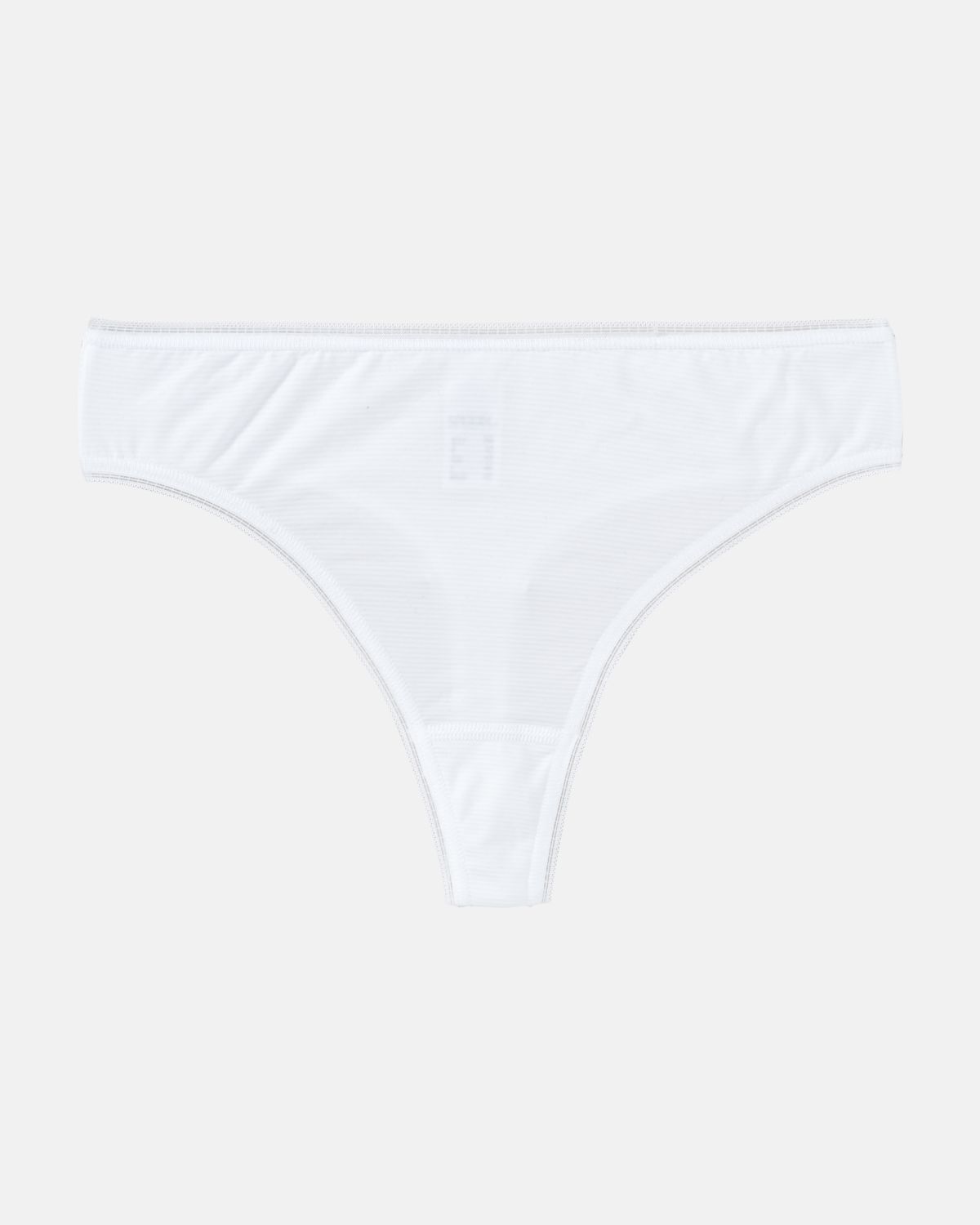 String Tanga in weiß aus der Serie Magic look, flach auf einer Oberfläche liegend.