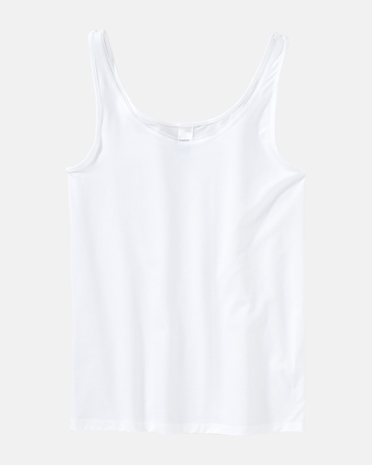 Achselhemd in weiß aus der Serie Magic look, flach auf einer Oberfläche liegend.