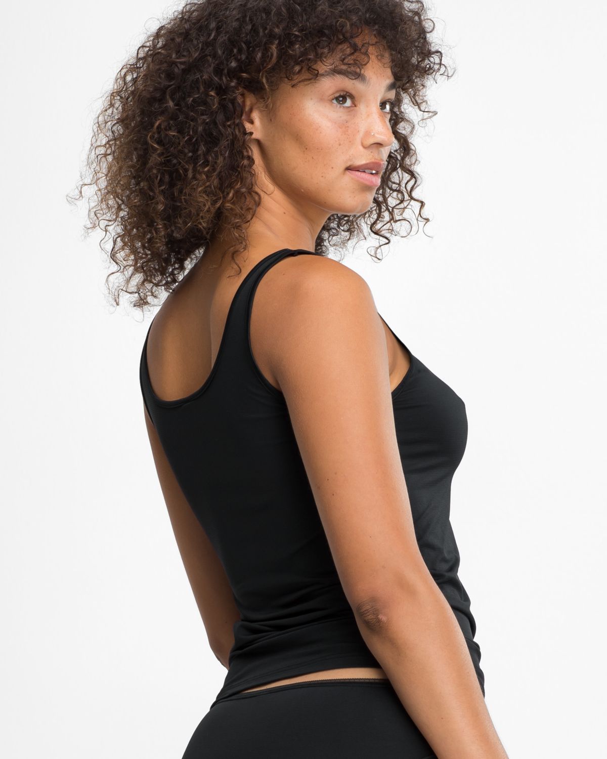 Model trägt Achselhemd in schwarz aus der Serie Magic look, Ansicht von hinten.