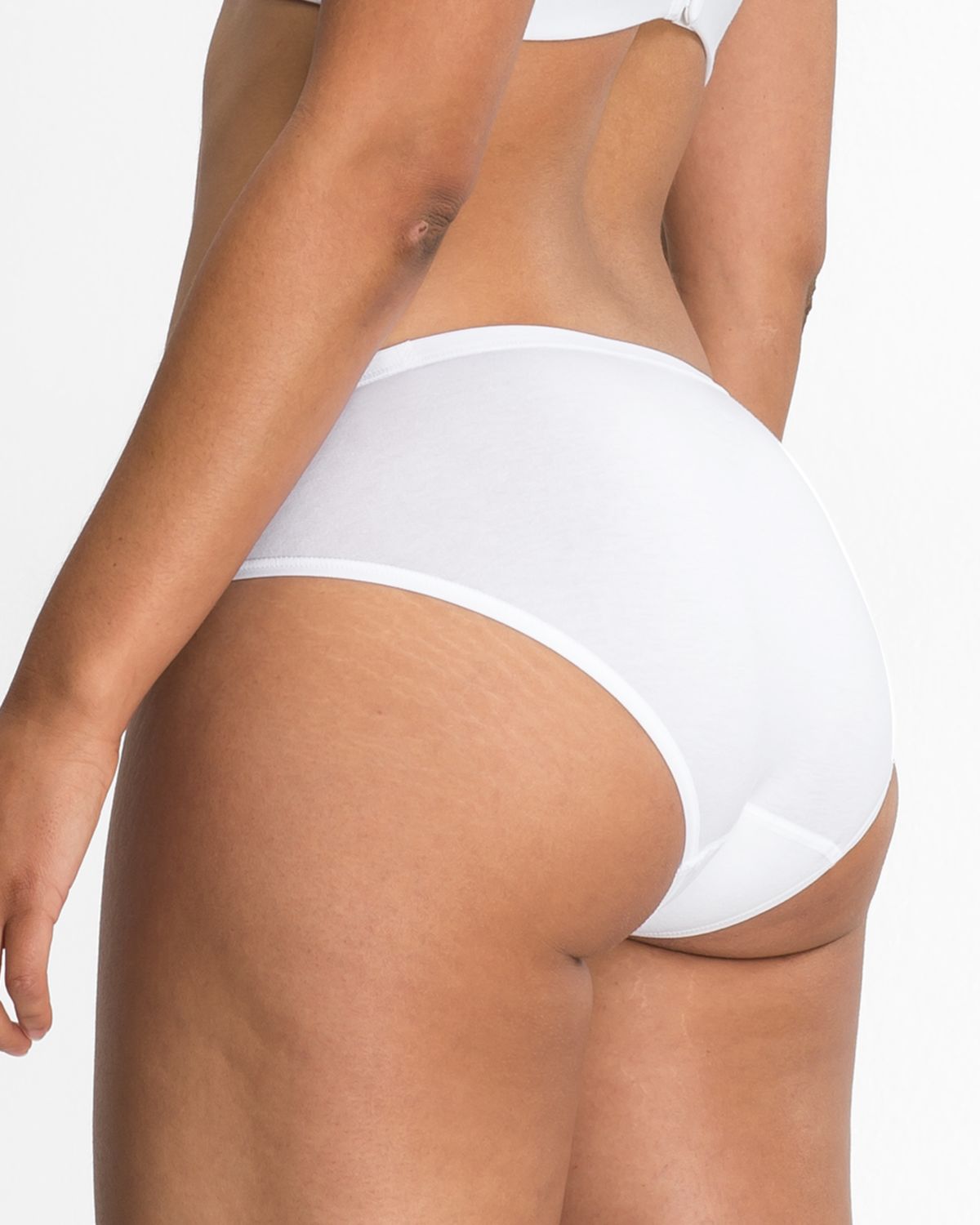 Model trägt Bikinislip in off white aus der Serie Natural Beauty, Ansicht von hinten.
