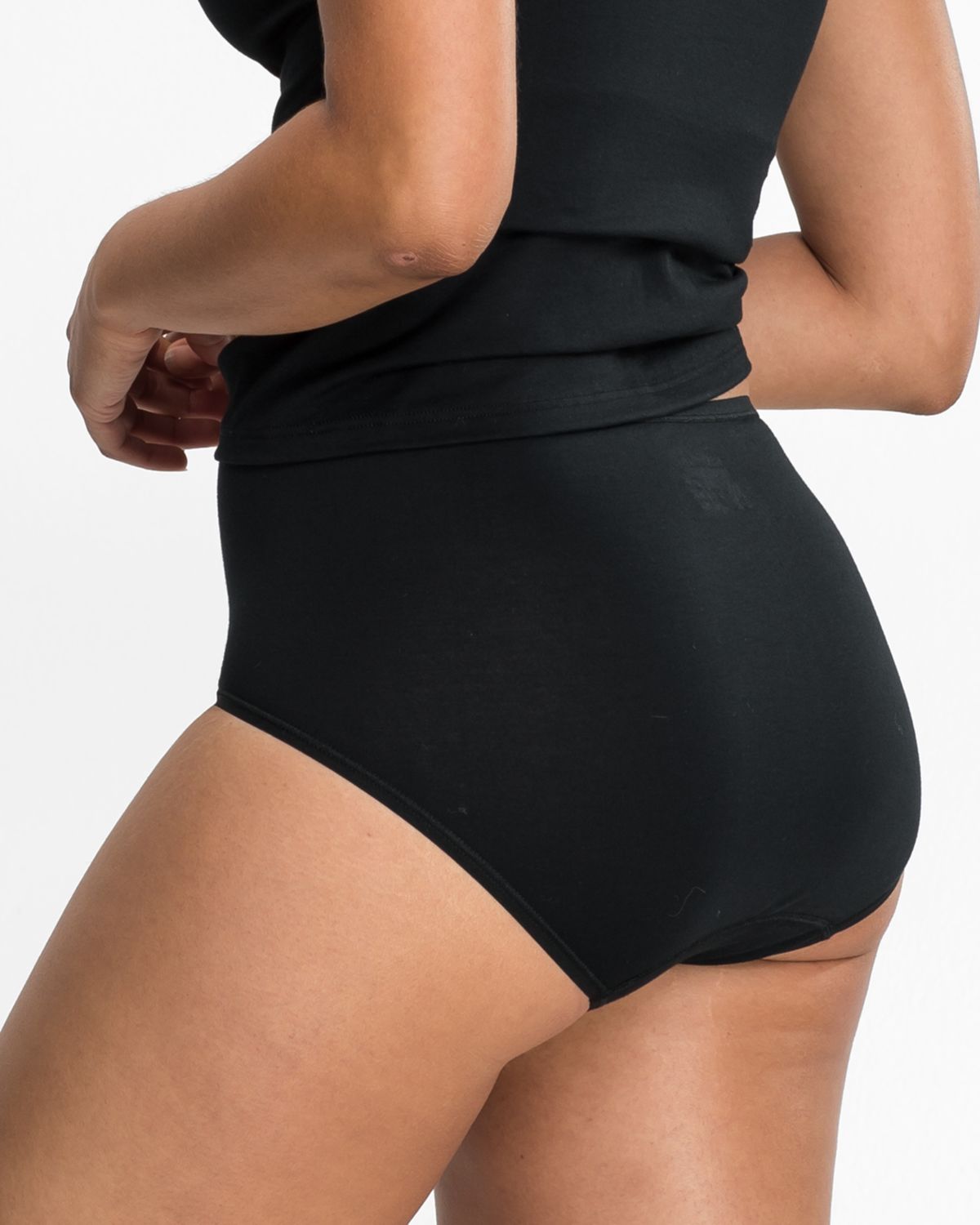 Model trägt Maxislip in schwarz aus der Serie Natural Beauty, Ansicht von hinten.