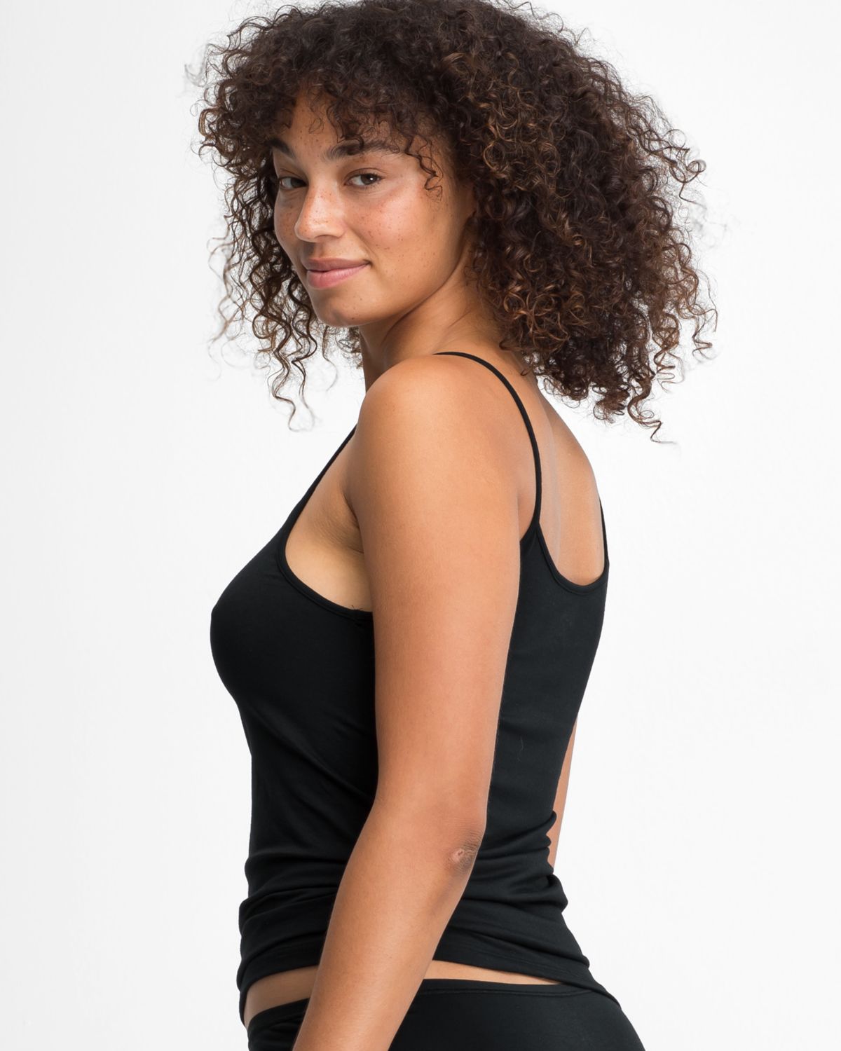 Model trägt Spaghettitop in schwarz aus der Serie Natural Beauty, Ansicht von hinten.