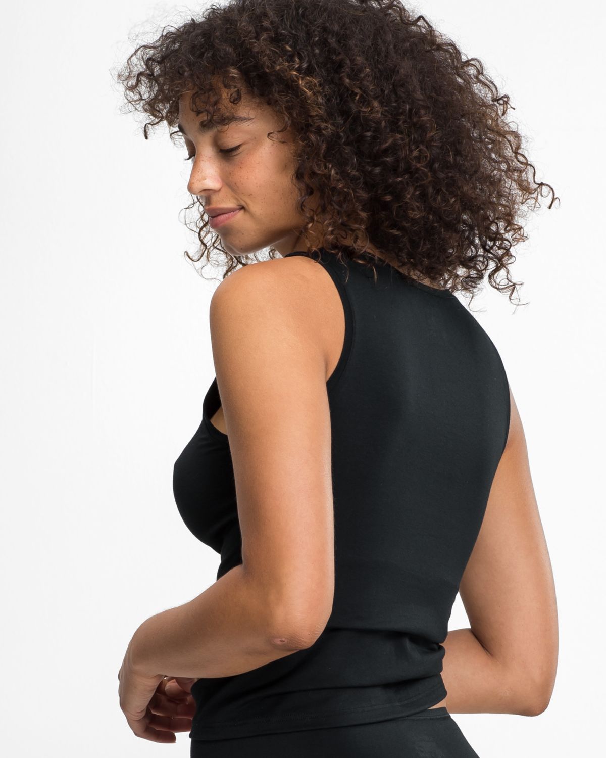 Model trägt Achseltop in schwarz aus der Serie Natural Beauty, Ansicht von hinten.