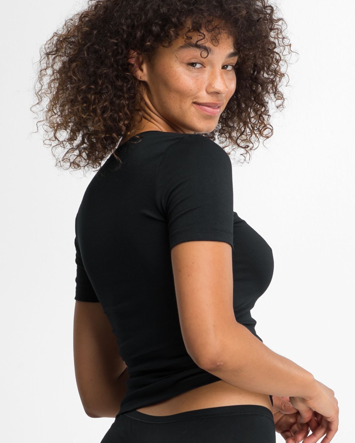 Model trägt Shirt 1/4 Arm in schwarz aus der Serie Natural Beauty, Ansicht von hinten.