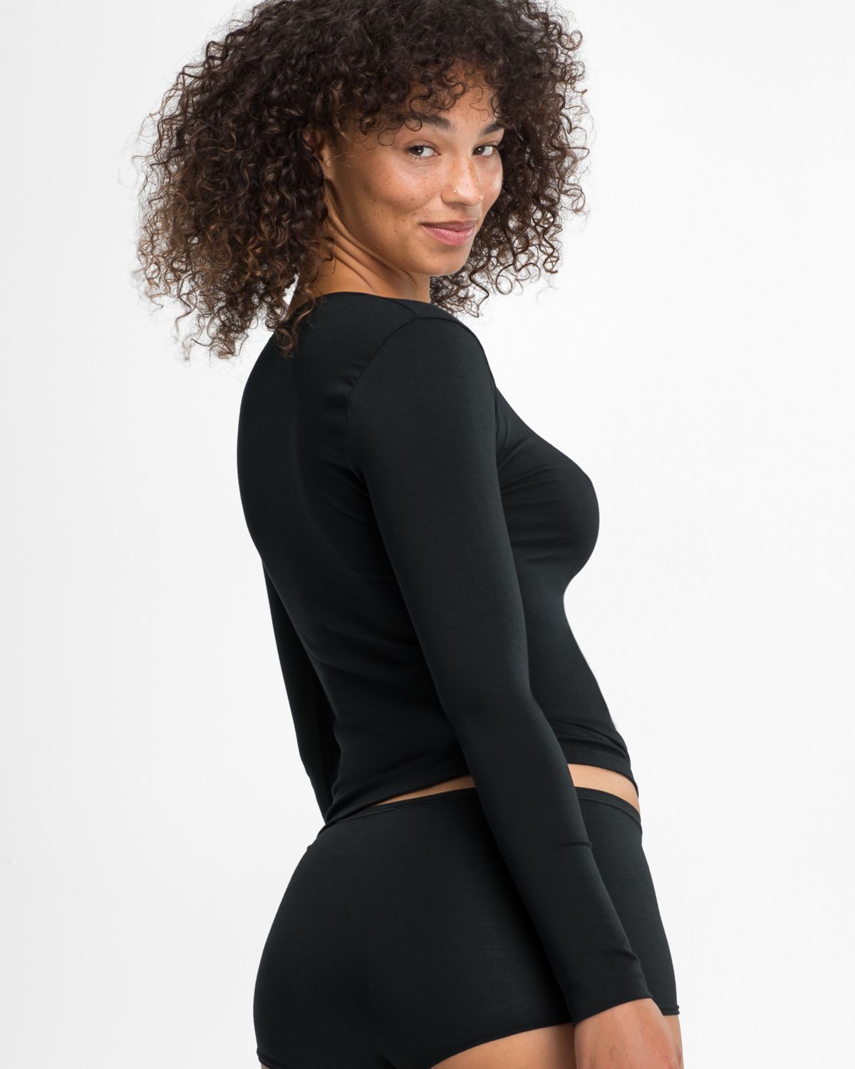 Model trägt Shirt 1/1 Arm in schwarz aus der Serie Natural Beauty, Ansicht von hinten.