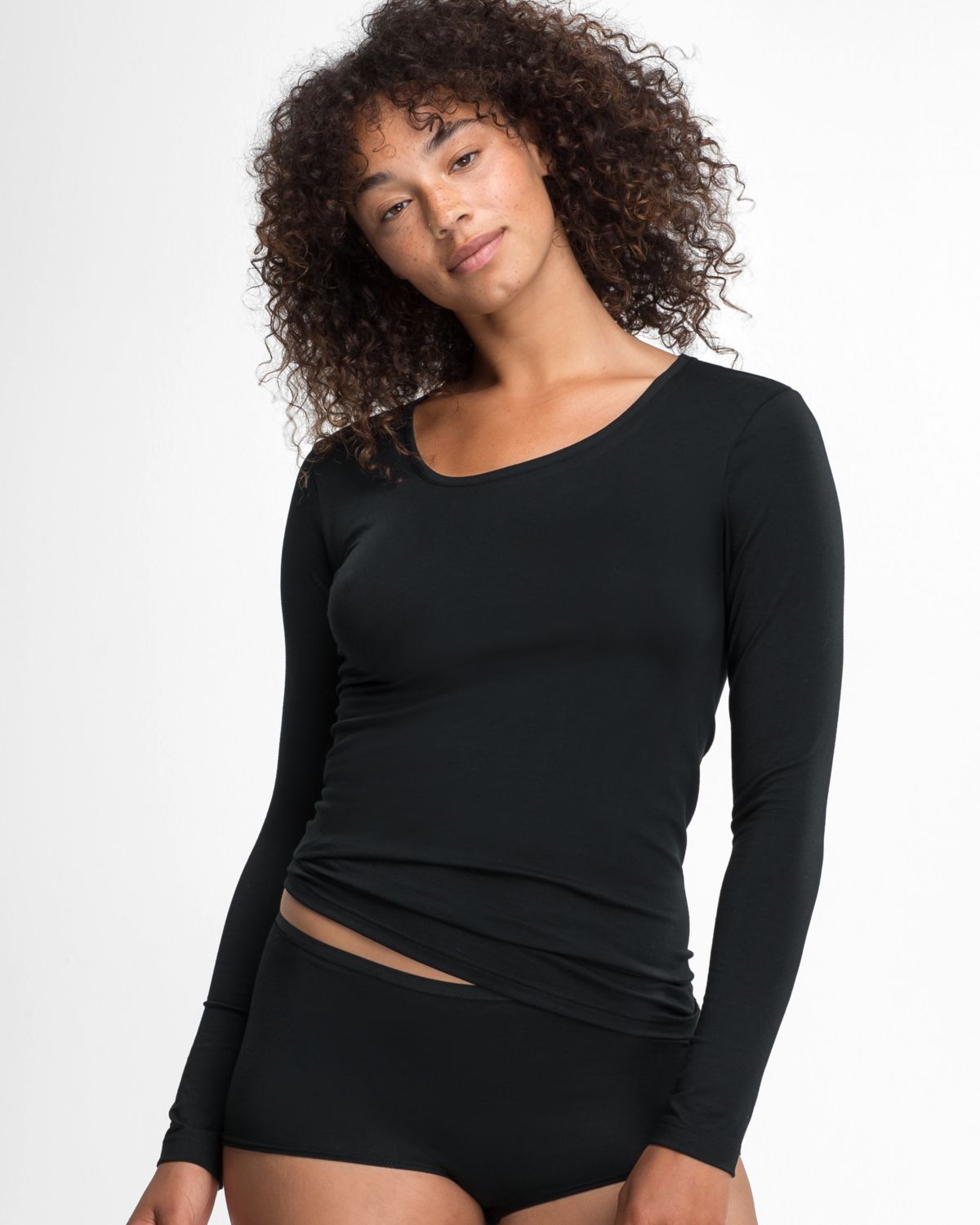 Model trägt Shirt 1/1 Arm in schwarz aus der Serie Natural Beauty, Ansicht von vorne.