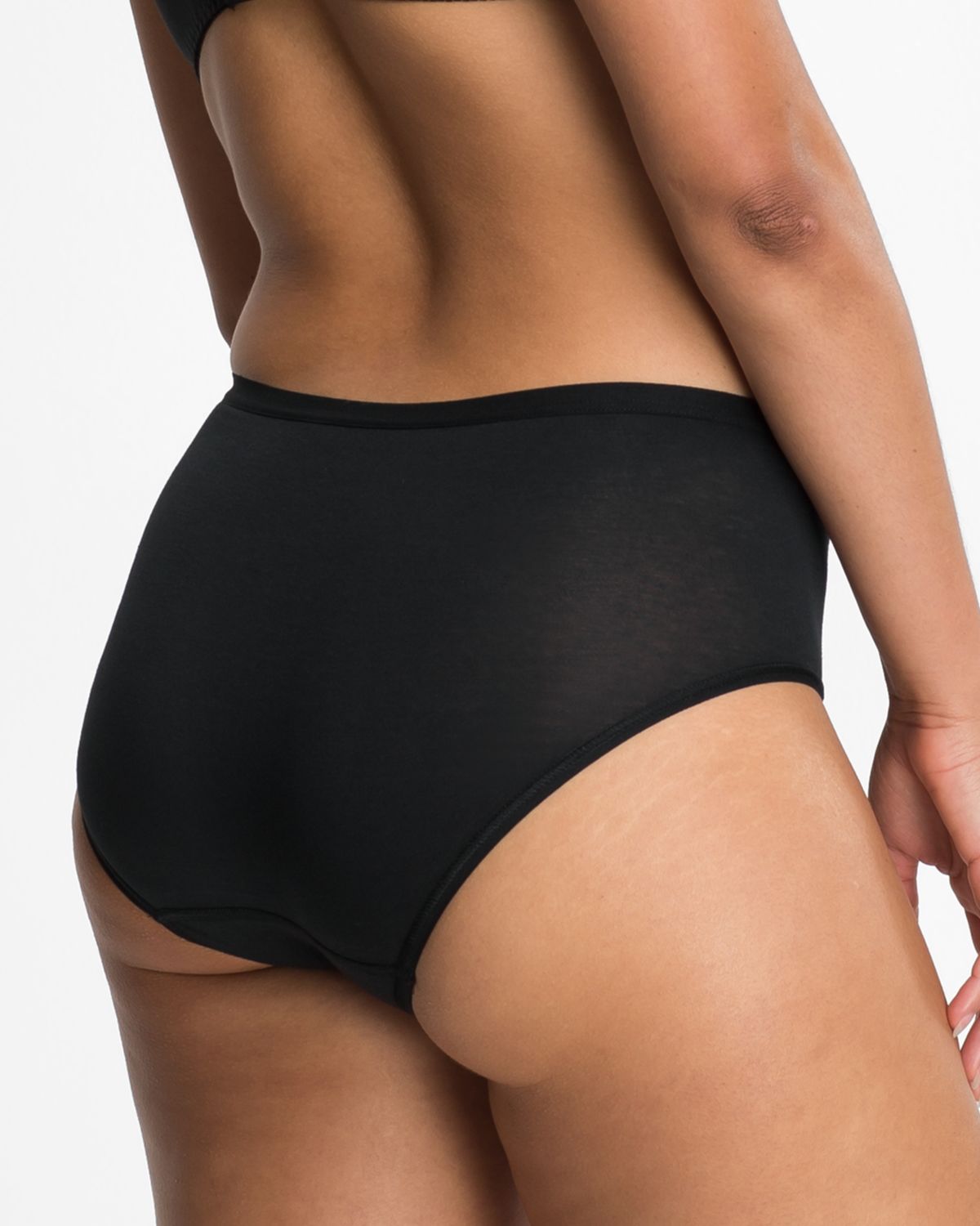 Model trägt Midislip in schwarz aus der Serie Take two, Ansicht von hinten.