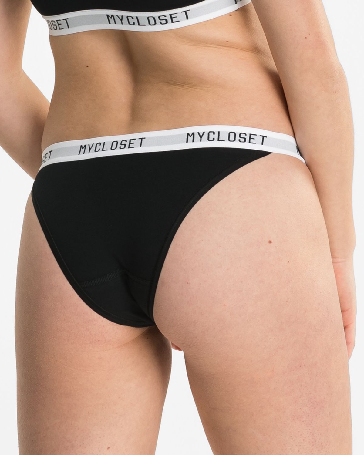 Model trägt Tanga in schwarz aus der Serie Logo Lover, Ansicht von hinten.