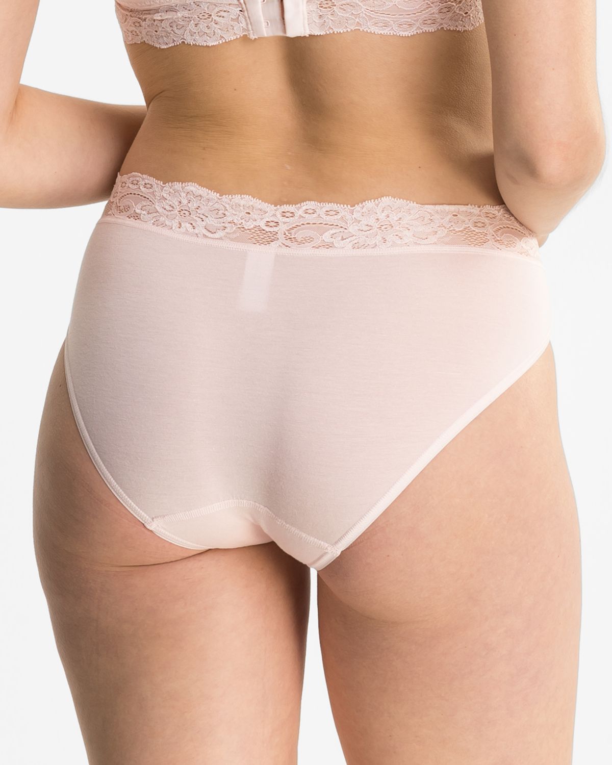Model trägt Bikinislip in lychee aus der Serie Sensuelle Lace, Ansicht von hinten.