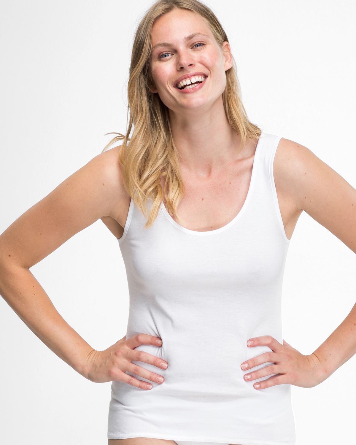 Model trägt Achselhemd in weiß aus der Serie Britta, Ansicht von vorne.