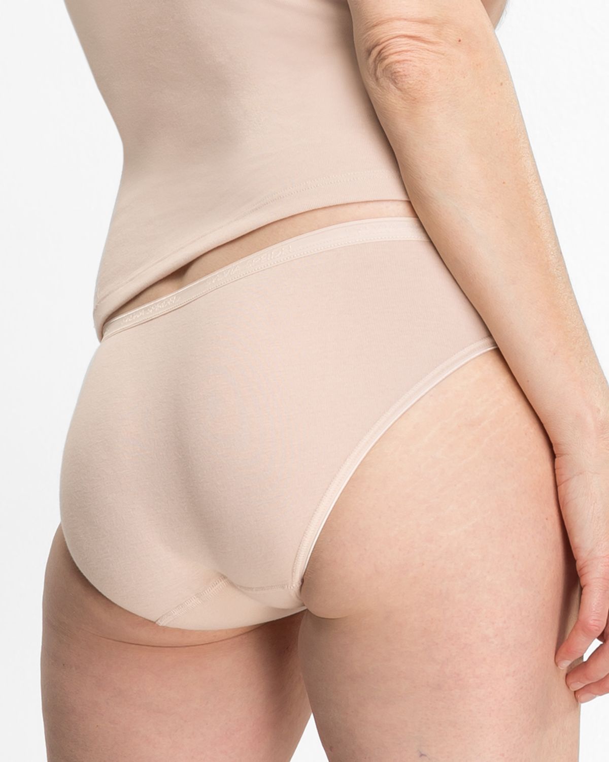 Model trägt Minislip in honey aus der Serie Silke, Ansicht von hinten.