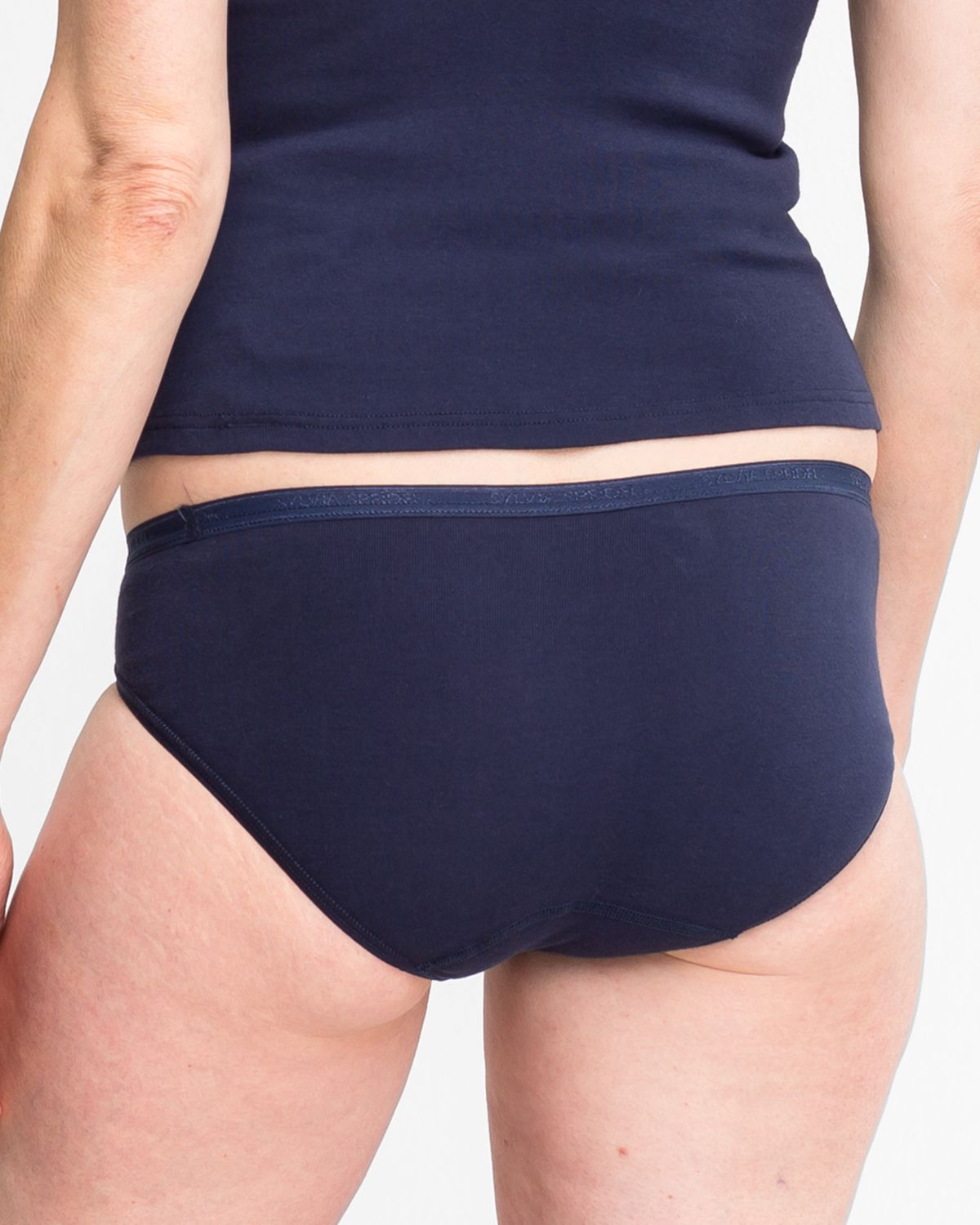 Model trägt Minislip in blueberry aus der Serie Silke, Ansicht von hinten.