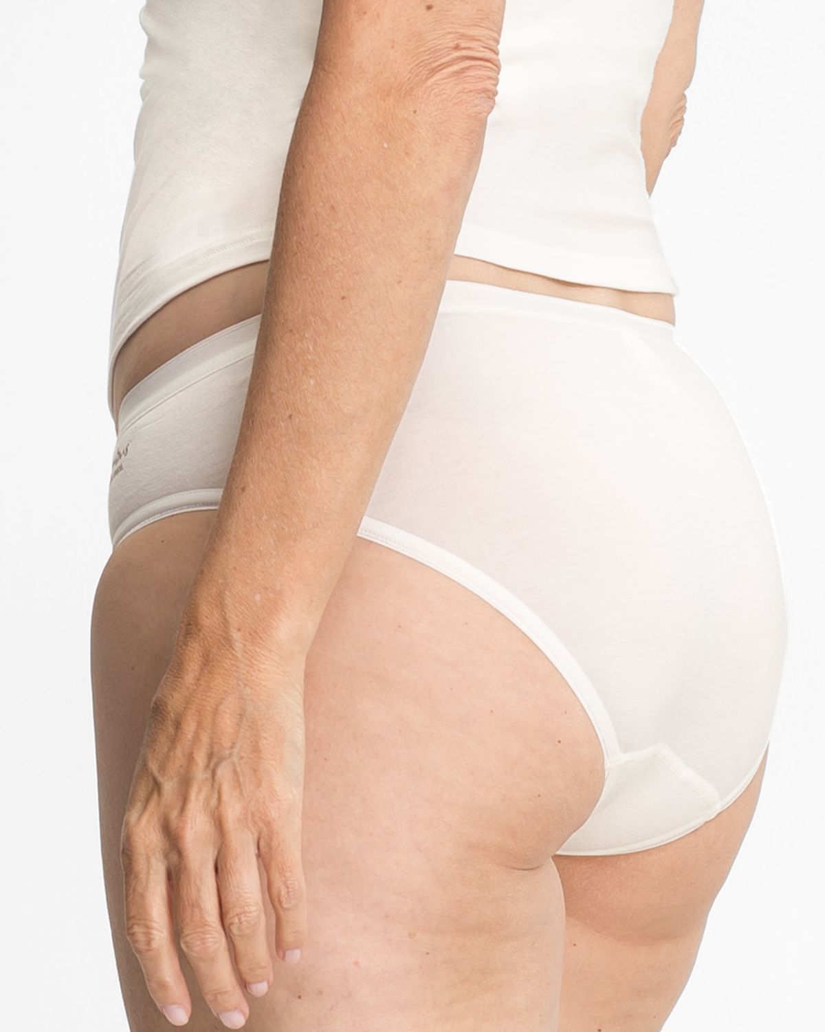 Model trägt Minislip in elfenbein aus der Serie Swenja, Ansicht von hinten.