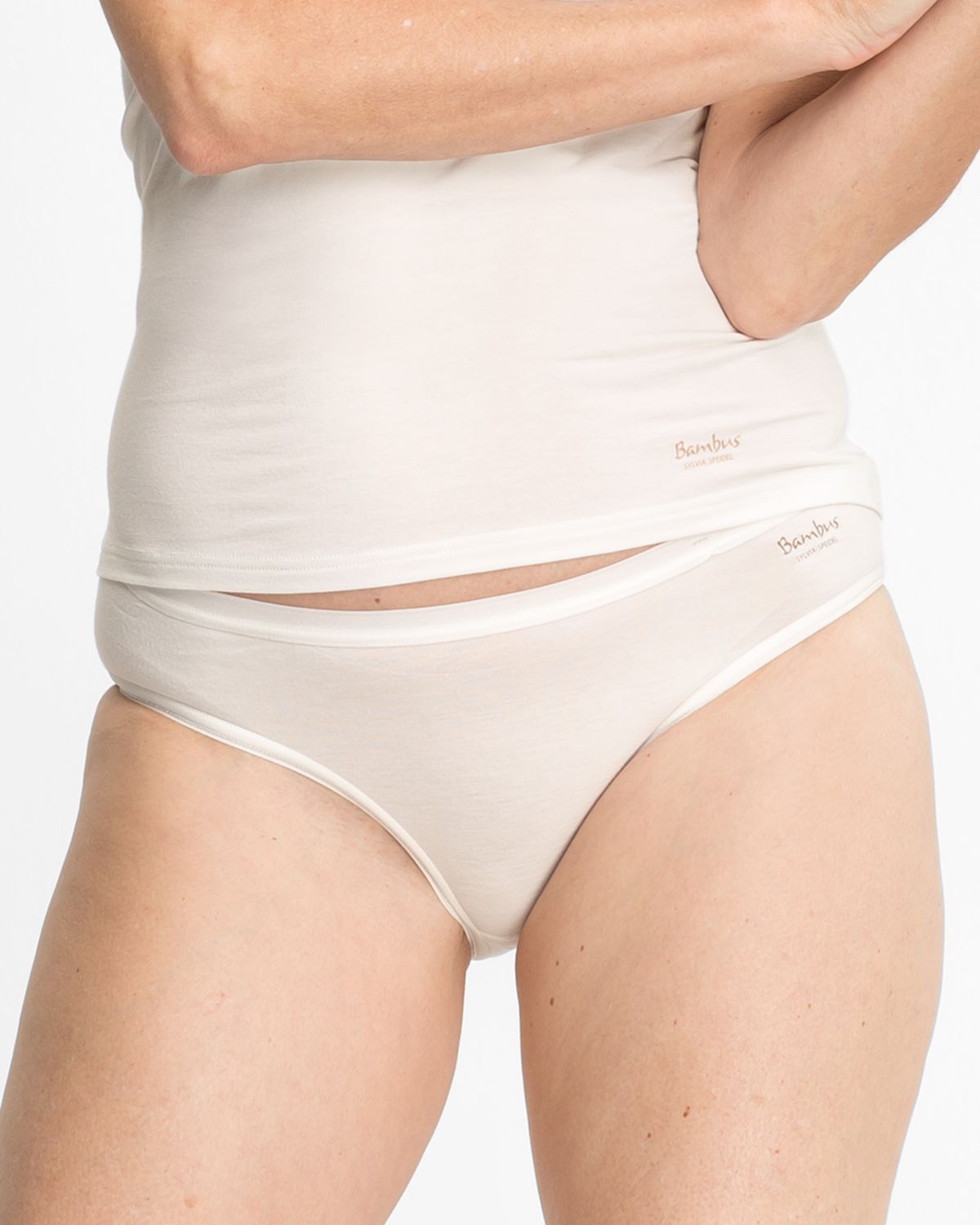 Model trägt Minislip in elfenbein aus der Serie Swenja, Ansicht von vorne.